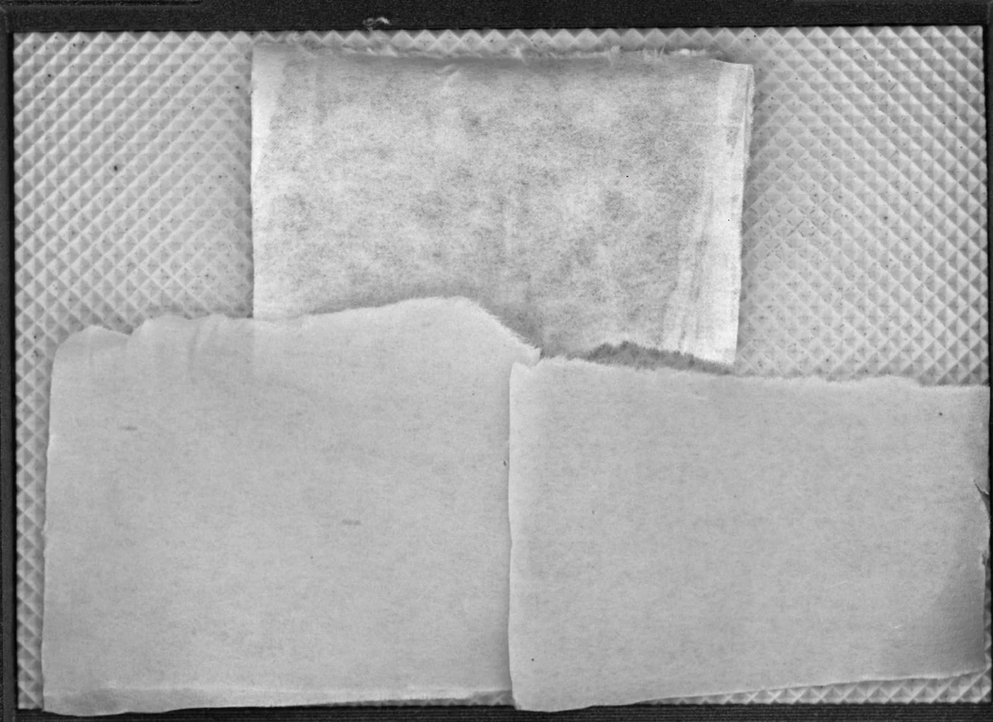 Banda de 850 nm em tons de cinza: o papel branco com textura manchada, em flocos, e uma faixa clara junto à borda direita; as metades de papel marrom quase tão claras quanto o branco